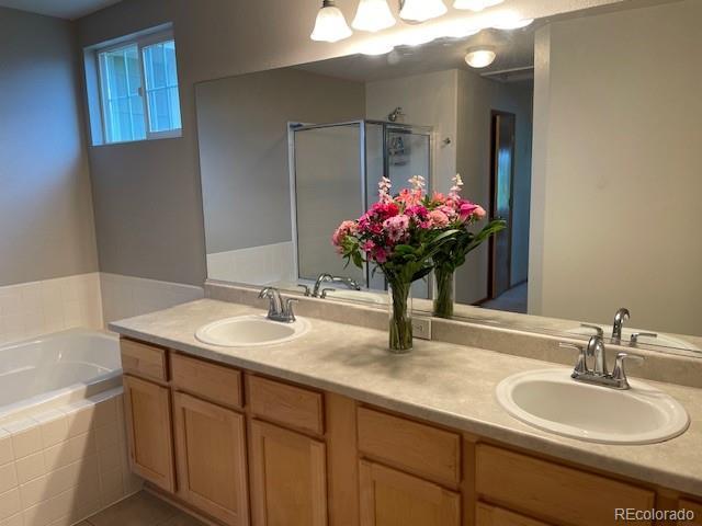 14642 Williams St, Thornton, CO 80602 - full bathroom with a garden tub, double vanity, and a stall shower