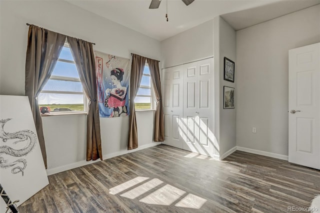 unfurnished bedroom featuring ceiling fan, multiple windows, a closet, and hardwood / wood-style floors