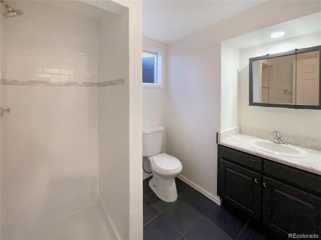 bathroom featuring toilet, vanity, tile patterned flooring, baseboards, and walk in shower