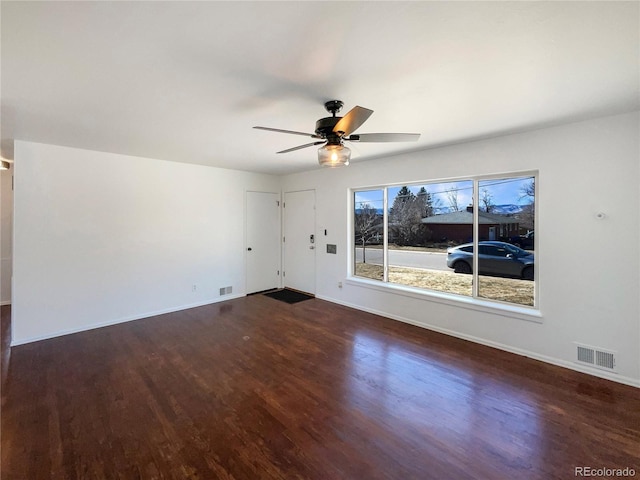 empty room featuring ceiling fan, wood finished floors, visible vents, and baseboards