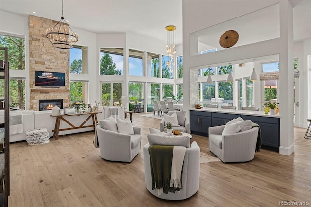 sunroom with a wealth of natural light, an inviting chandelier, and a fireplace