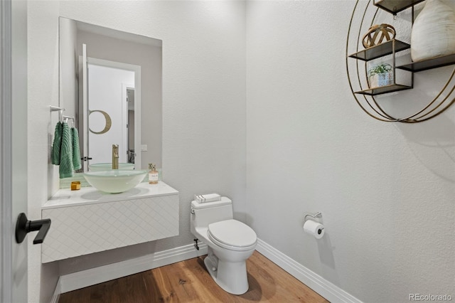 bathroom featuring sink, hardwood / wood-style floors, and toilet