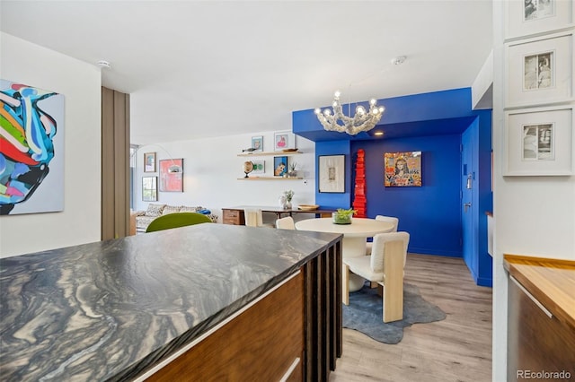 790 N Washington St Unit 407, Denver, CO 80203 - kitchen with a chandelier, light wood finished floors, and dark countertops