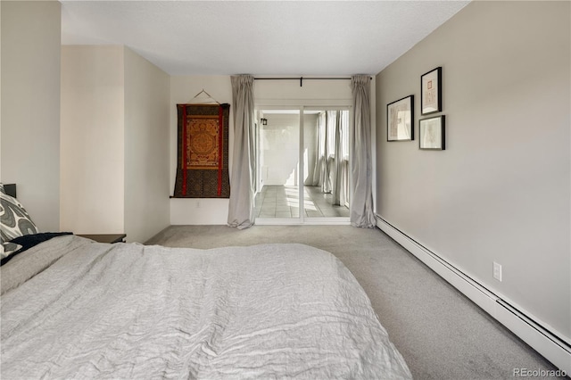 bedroom with access to outside, a baseboard heating unit, and carpet
