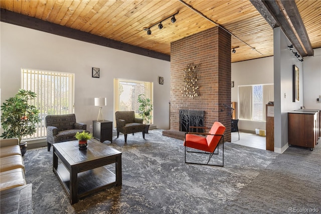 living room featuring track lighting, wooden ceiling, a fireplace, and carpet floors
