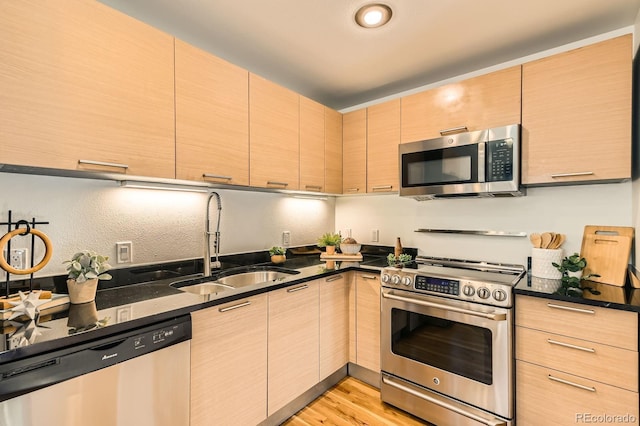 2837 Vallejo St Unit 102, Denver, CO 80211 - kitchen featuring appliances with stainless steel finishes, light brown cabinetry, light wood-type flooring, and modern cabinets
