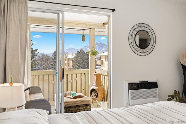 bedroom with a wall mounted AC, a mountain view, and access to outside