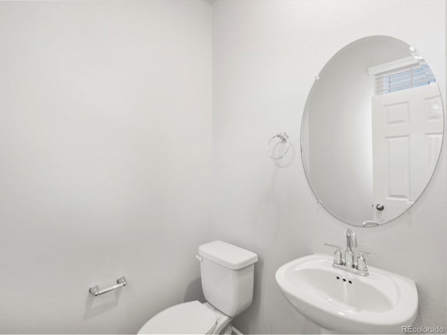 half bath featuring toilet and a sink