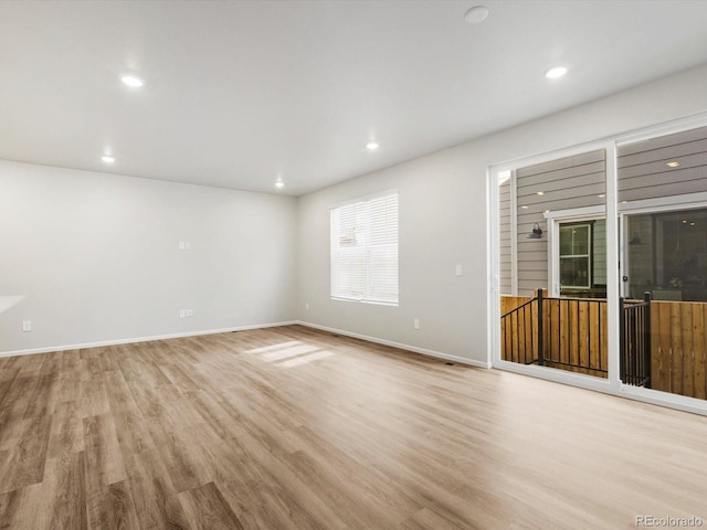 unfurnished living room with baseboards, recessed lighting, and light wood-style flooring