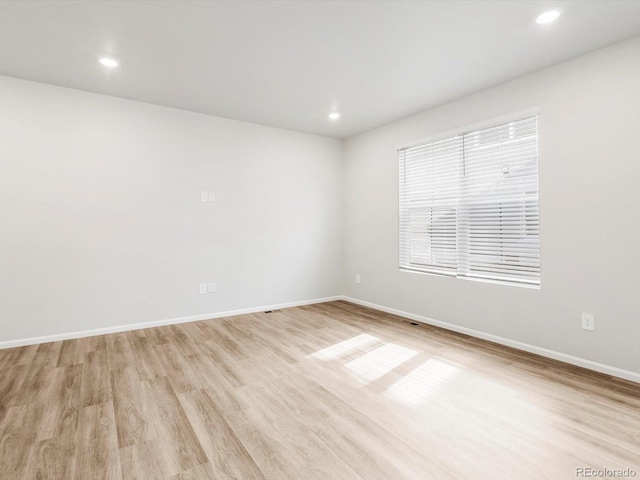 unfurnished room with recessed lighting, baseboards, and light wood-style floors