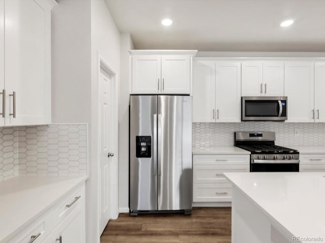 kitchen with light countertops, backsplash, white cabinets, and stainless steel appliances