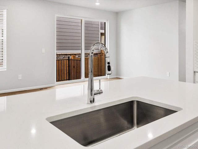 details featuring light countertops, recessed lighting, and a sink
