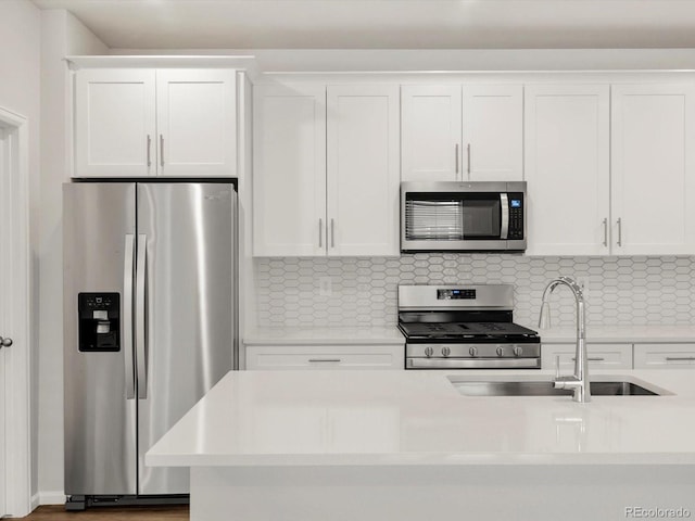 kitchen featuring light countertops, stainless steel appliances, white cabinetry, and a sink
