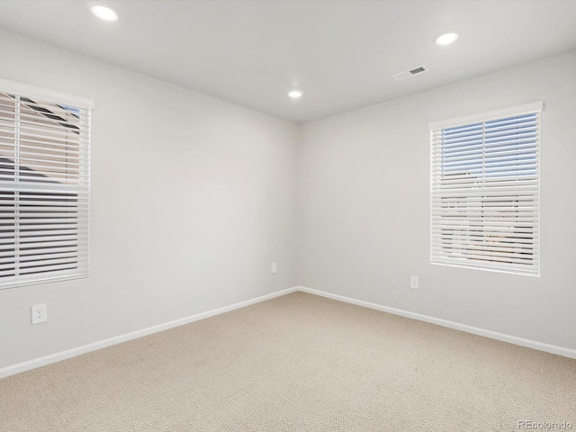 spare room featuring baseboards, carpet, recessed lighting, and visible vents