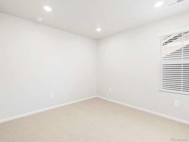 empty room with visible vents, recessed lighting, baseboards, and light colored carpet