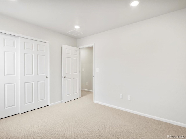 unfurnished bedroom featuring light colored carpet, recessed lighting, baseboards, and a closet
