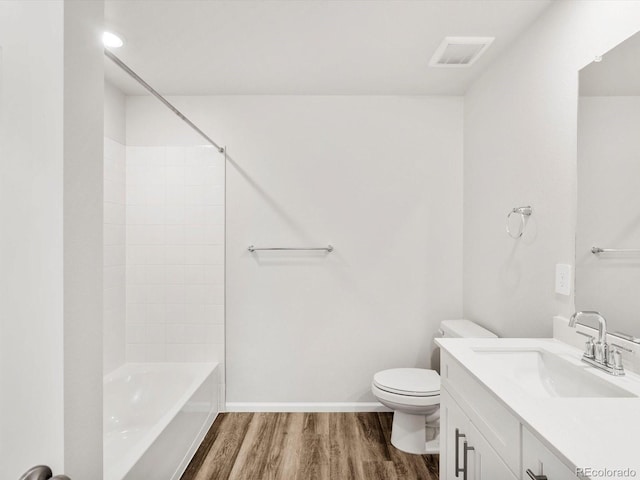 bathroom featuring vanity, toilet, baseboards, wood finished floors, and visible vents