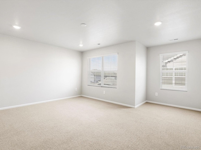 spare room with recessed lighting, baseboards, light carpet, and a healthy amount of sunlight