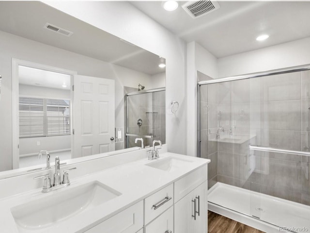 full bath featuring visible vents, a sink, and a shower stall