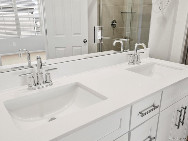 bathroom featuring double vanity, a shower stall, and a sink