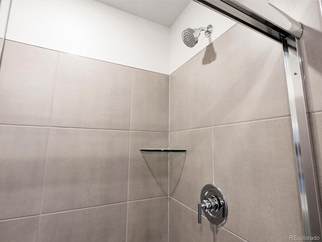 interior details featuring tiled shower