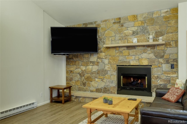 living room with wood-type flooring, a stone fireplace, baseboard heating, and lofted ceiling