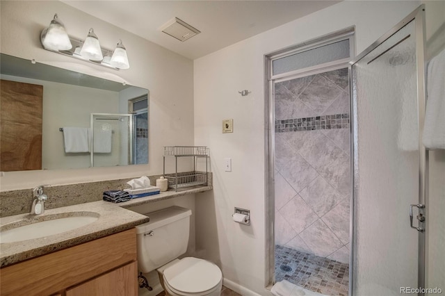 bathroom with vanity, toilet, and a shower with door