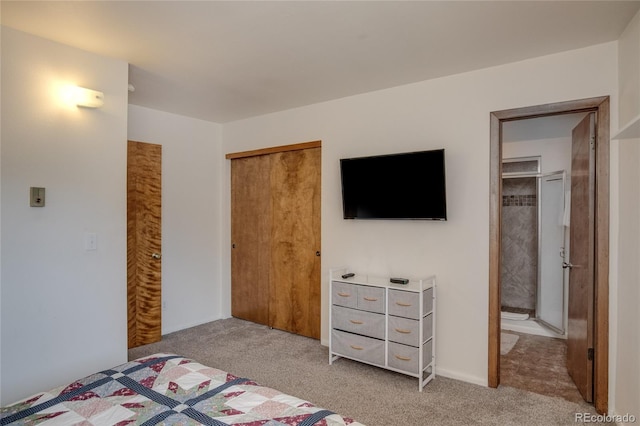 bedroom with connected bathroom, light colored carpet, and a closet