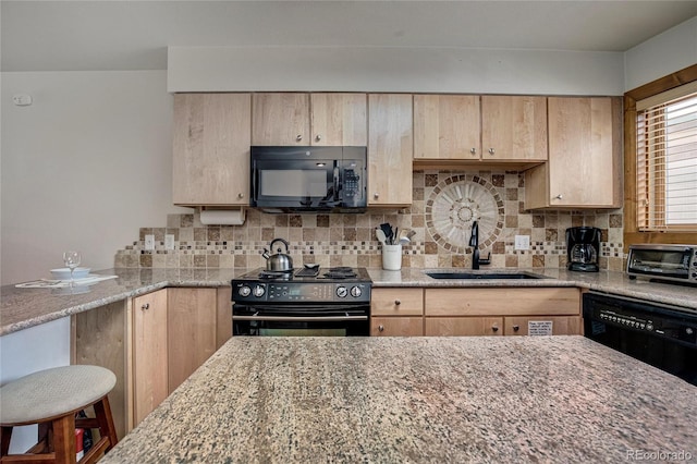 kitchen with light stone countertops, light brown cabinetry, sink, and black appliances