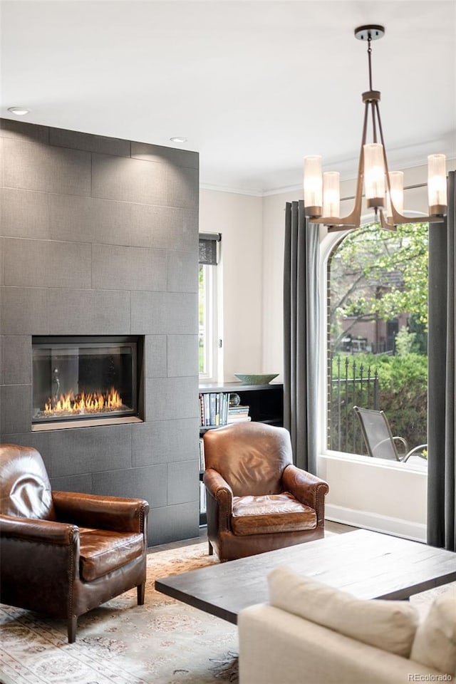 628 Cherry St, Denver, CO 80220 - living area with crown molding, a fireplace, wood finished floors, and a chandelier