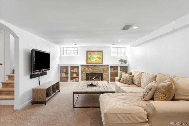 628 Cherry St, Denver, CO 80220 - living area featuring light carpet, stairway, a stone fireplace, arched walkways, and baseboards