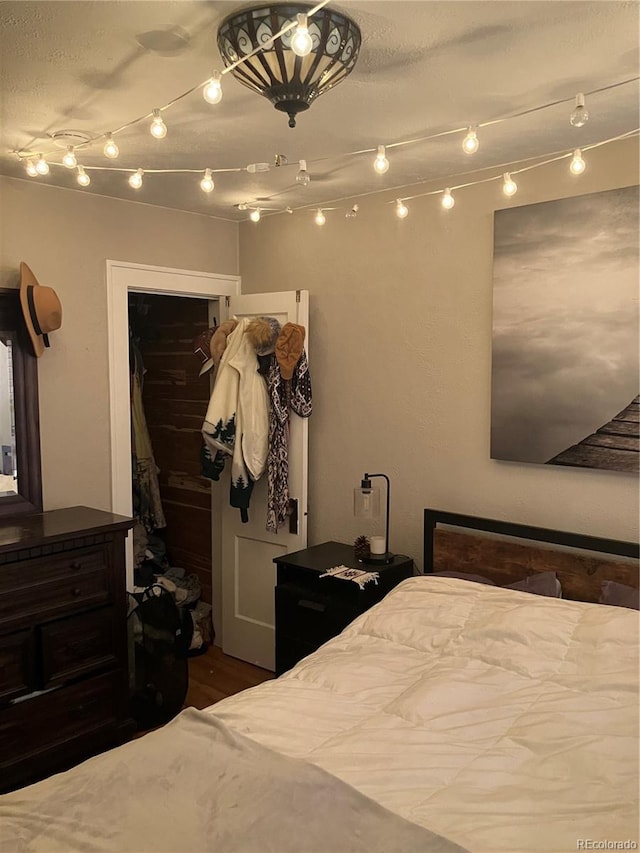 bedroom with dark hardwood / wood-style flooring and a closet