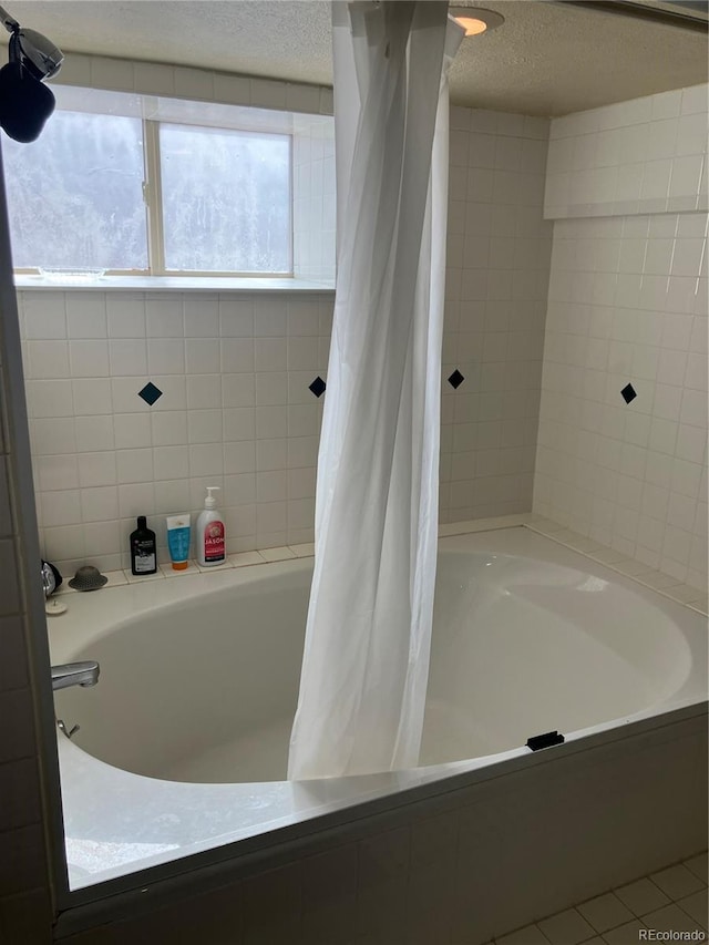 bathroom with a healthy amount of sunlight, a textured ceiling, shower / tub combo, and tile floors