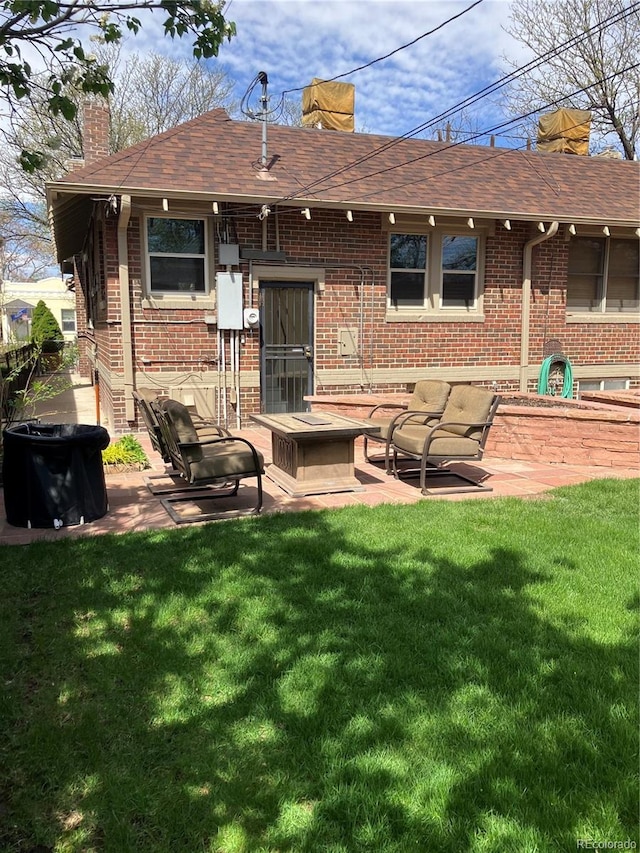 rear view of property featuring a lawn and a patio