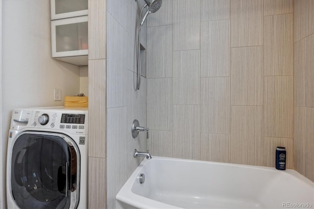 bathroom featuring tiled shower / bath combo and washer / clothes dryer