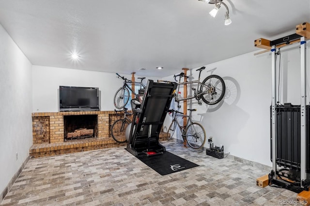 workout area featuring a brick fireplace