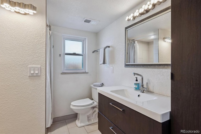 bathroom with curtained shower, a textured ceiling, toilet, vanity, and tile patterned flooring