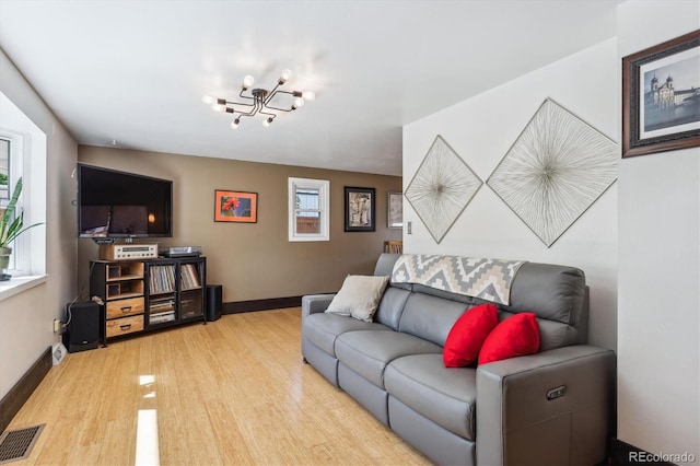 living room with a notable chandelier and light wood-type flooring