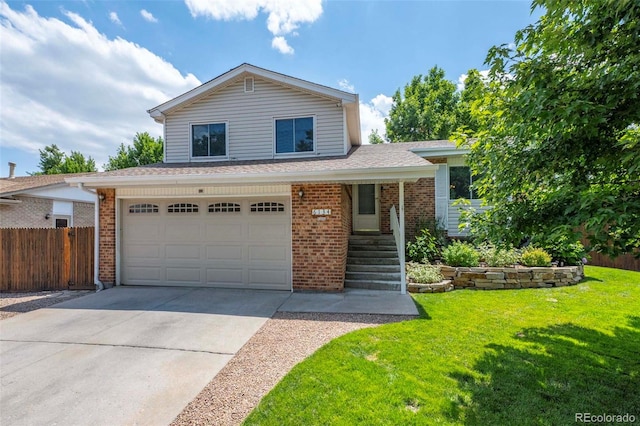 split level home featuring brick siding, concrete driveway, a front yard, and fence