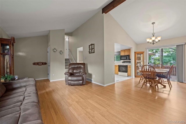 living room with visible vents, an inviting chandelier, stairs, light wood-style floors, and beamed ceiling