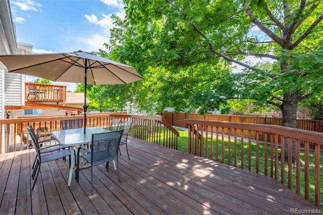 wooden terrace featuring outdoor dining area and fence