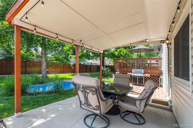 view of patio featuring a grill, a wooden deck, outdoor dining area, and a fenced backyard