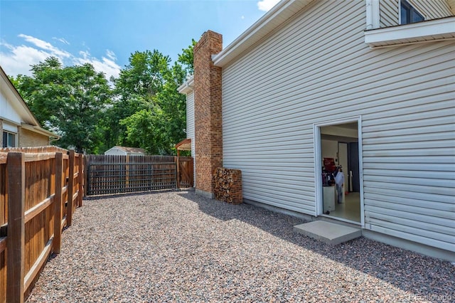 view of property exterior featuring a chimney and fence