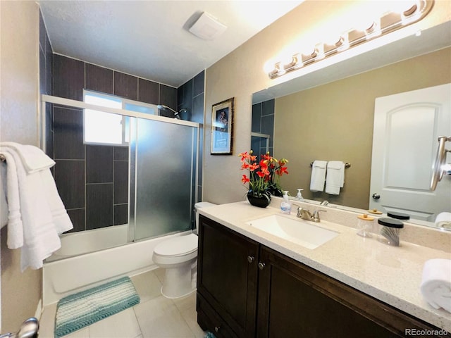 full bathroom featuring enclosed tub / shower combo, vanity, tile patterned floors, and toilet