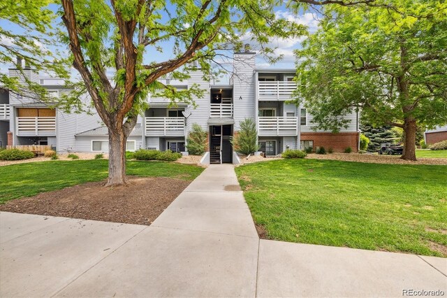 multi unit property with a chimney and a front yard