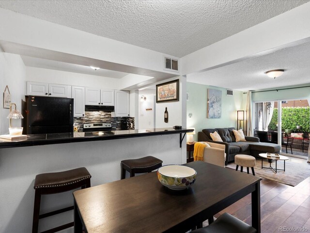 dining area featuring a textured ceiling and wood finished floors