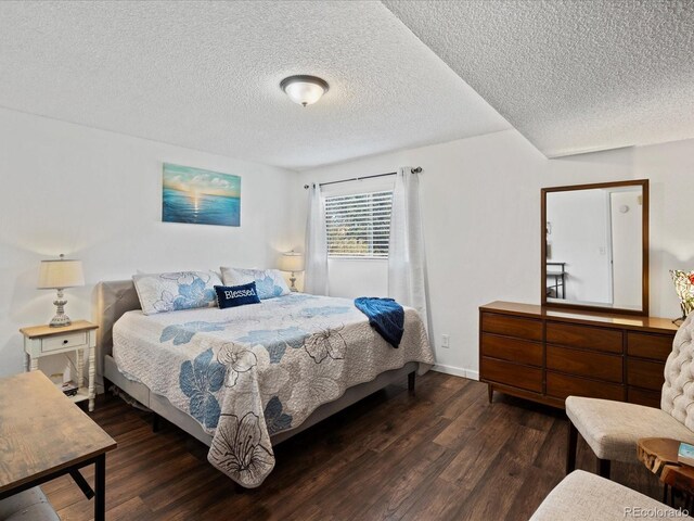 bedroom featuring a textured ceiling, wood finished floors, and baseboards