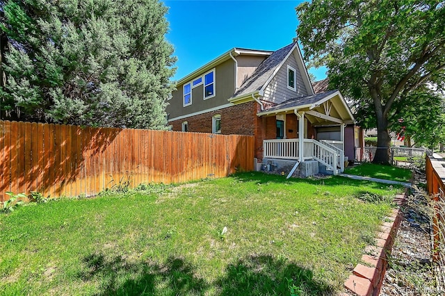 rear view of house with a porch and a yard