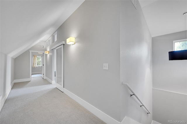 additional living space featuring vaulted ceiling and light colored carpet