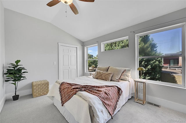 bedroom featuring a closet, ceiling fan, light colored carpet, and lofted ceiling